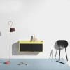 Modern interior scene featuring a yellow cabinet, decorative vase, red lamp, and black chair on a blue floor, relevant to digital marketing agency's design aesthetics.