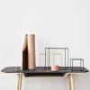 Decorative arrangement of geometric shapes and vases on a minimalist table, reflecting modern design aesthetics relevant to branding and digital marketing themes.