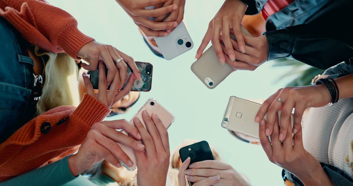 Hands holding various smartphones in a circle, emphasizing mobile engagement and social media interaction among users, relevant to marketing strategies for Lebanese businesses.