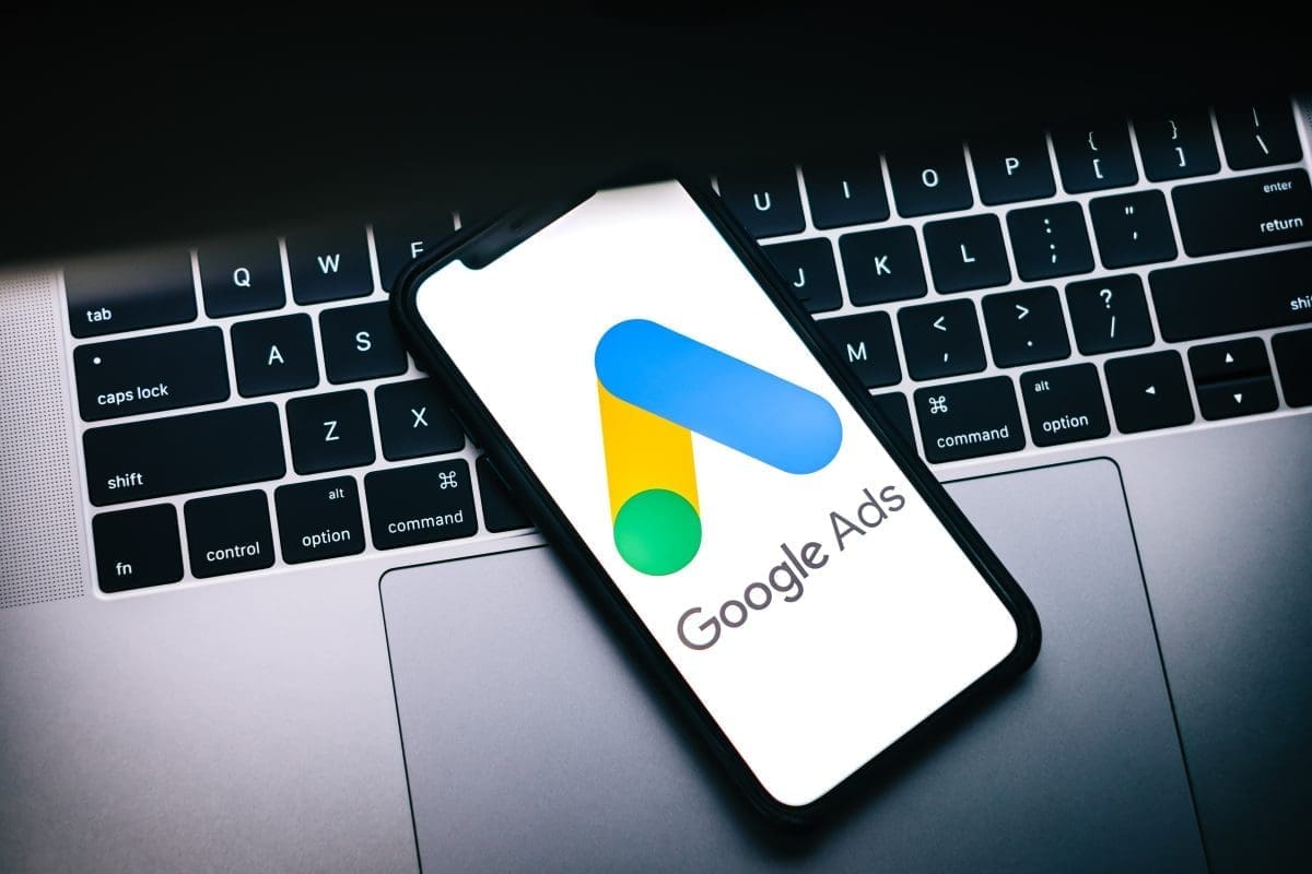 Google Ads logo displayed on smartphone resting on laptop keyboard, representing digital marketing solutions for targeted advertising campaigns.