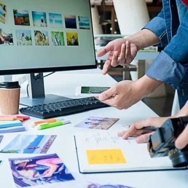 Creative workspace with people reviewing photos and color swatches on a desk.