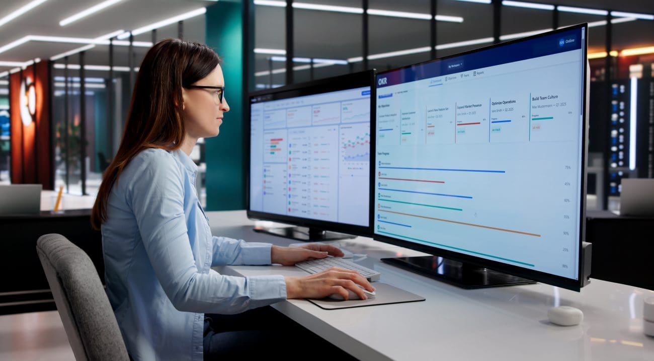 Woman analyzing social media marketing results on dual computer screens in Lebanon.