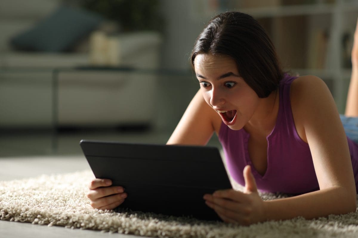 Woman looking shocked at tablet screen, social media pricing strategies for Bluemoon digital marketing agency in Lebanon.