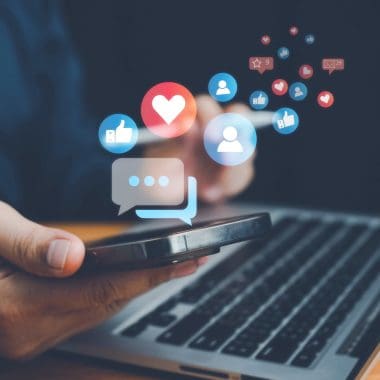 Social media strategy and engagement icons over a smartphone and laptop.